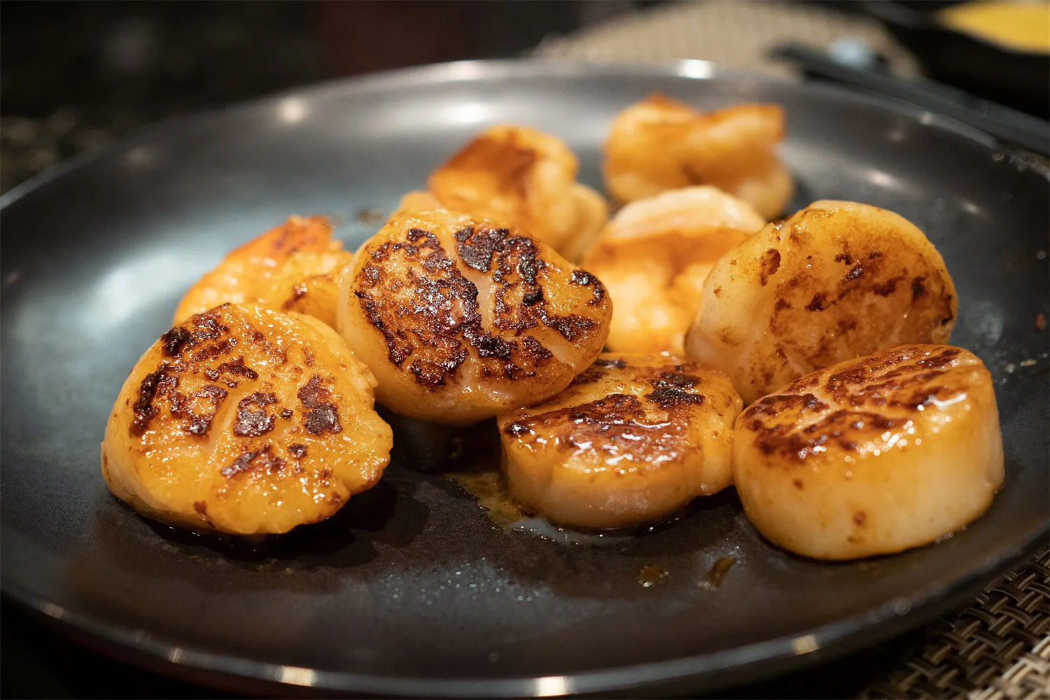Pan-seared scallops and shrimp on a black plate