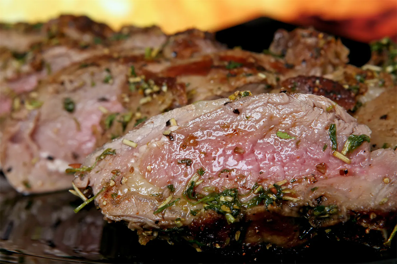 Herb-seasoned medium-rare roasted lamb slices